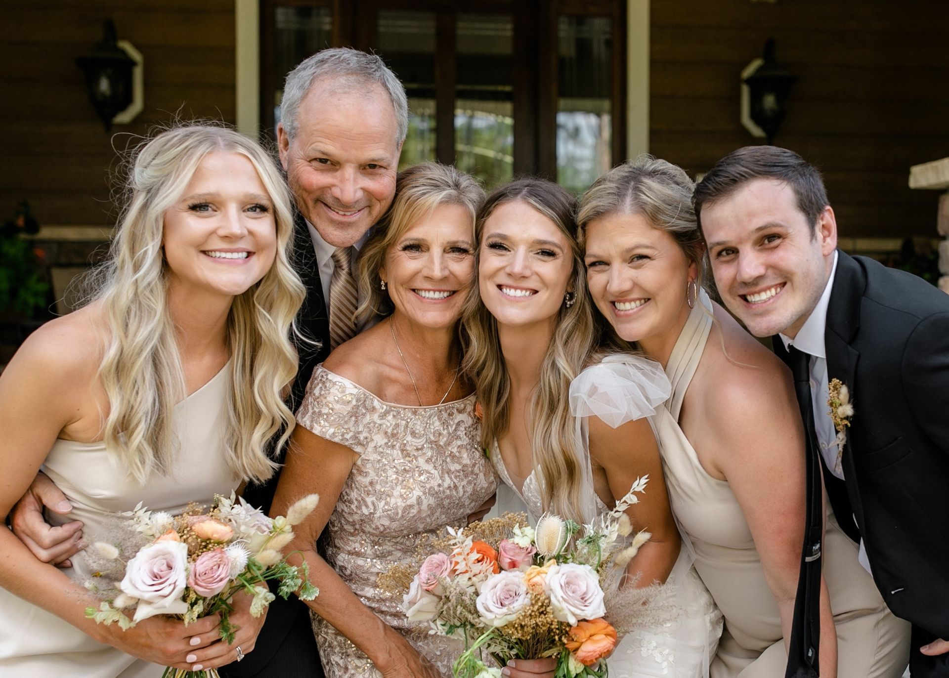 The bride and groom are posing for a picture with their family.
