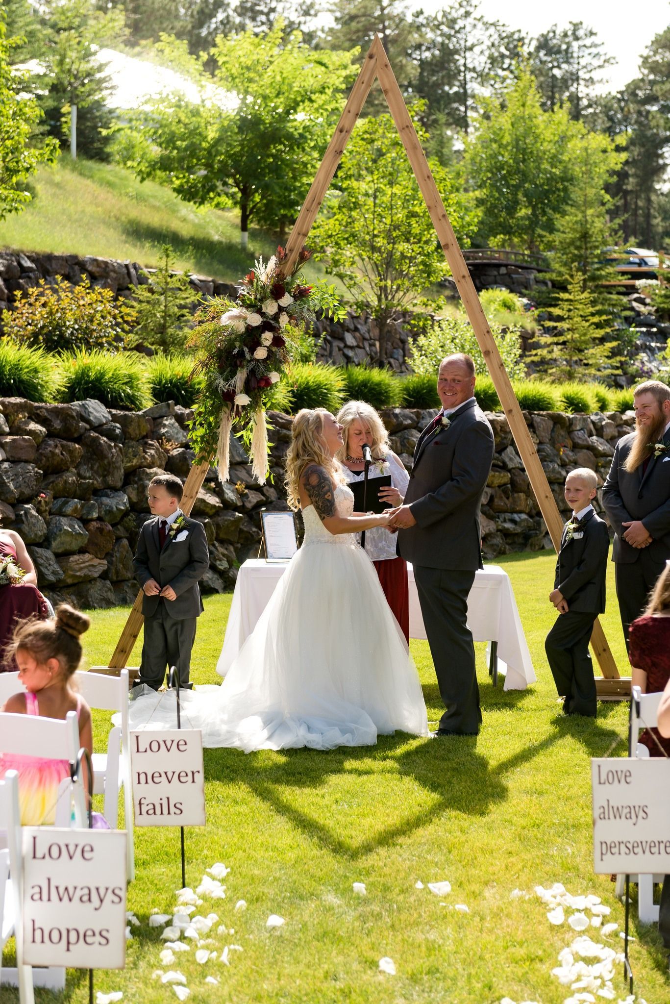 A bride and groom are holding hands during their wedding ceremony.