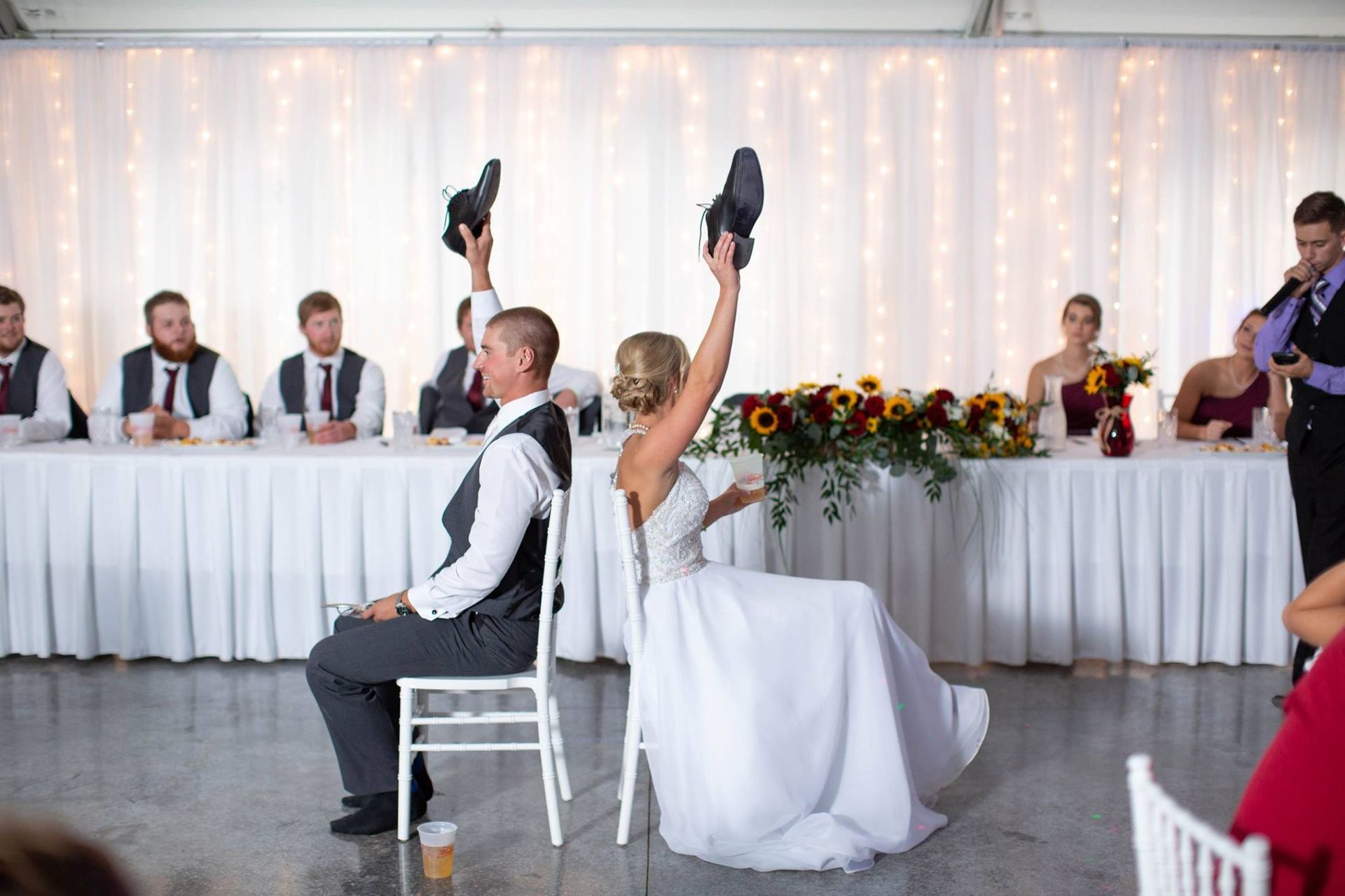 A bride and groom are playing a game at their wedding reception.
