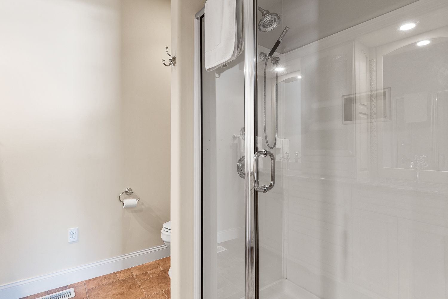 A bathroom with a walk in shower and a toilet.