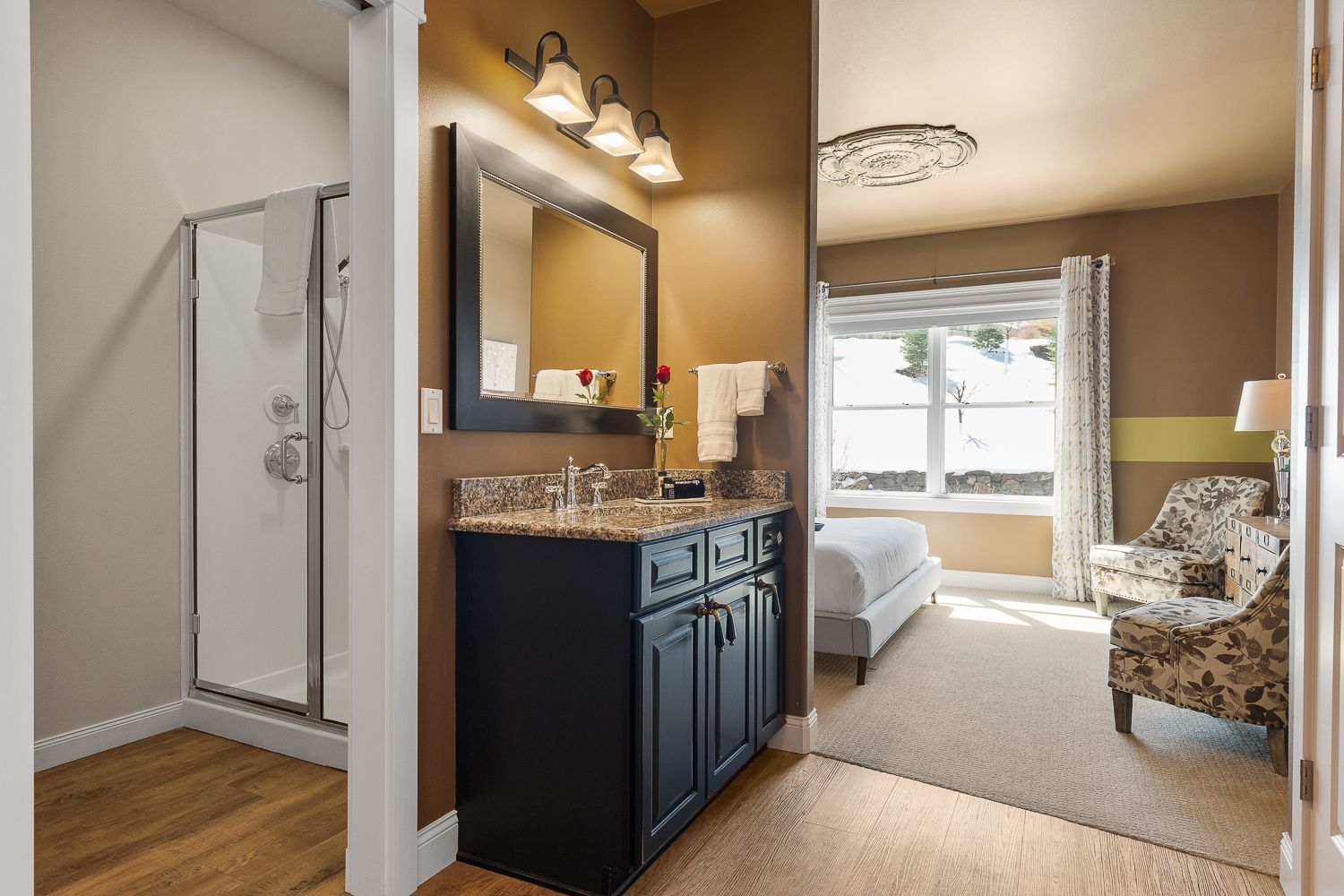 A bathroom with a sink , mirror , and walk in shower.