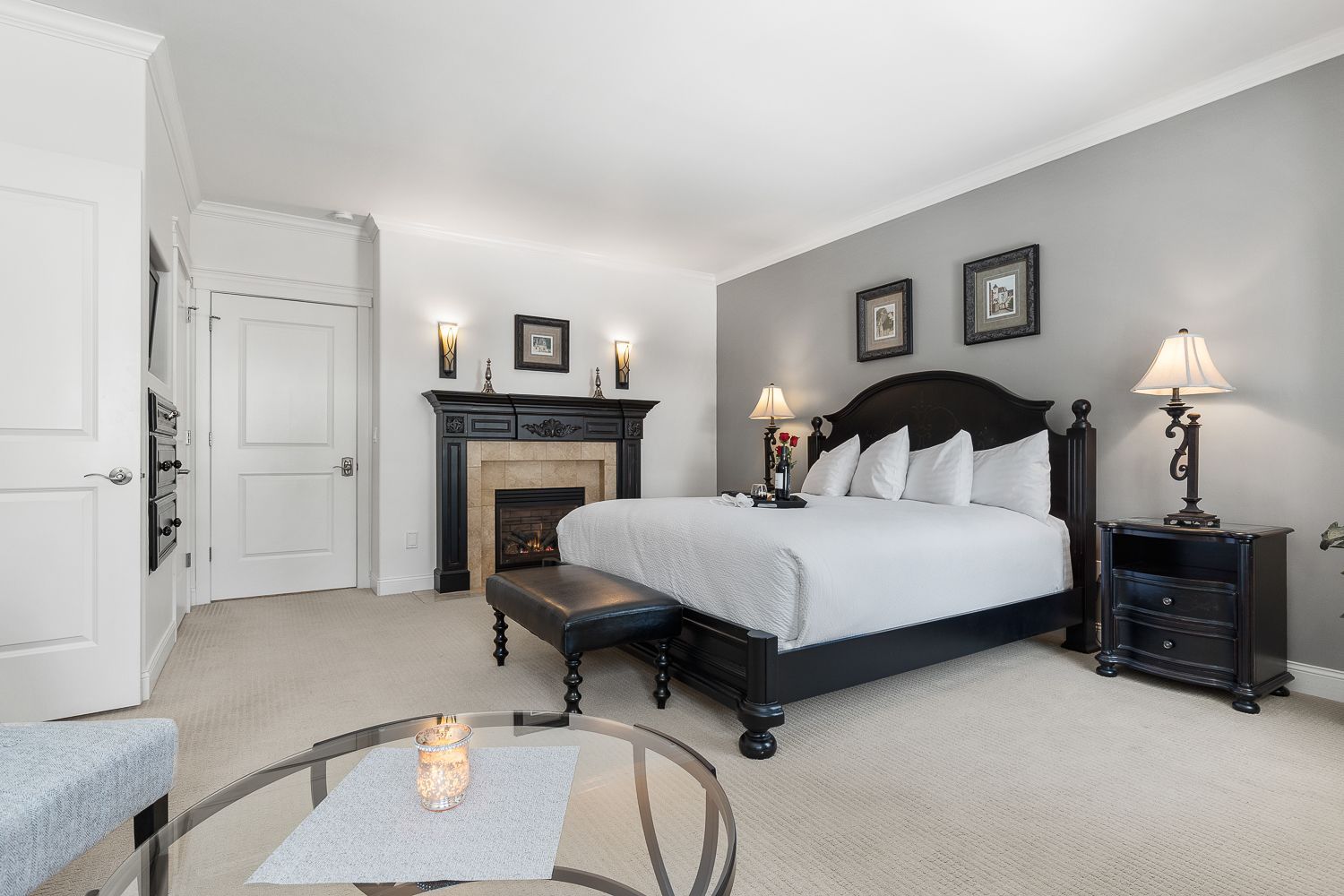 A bedroom with a king size bed and a fireplace.