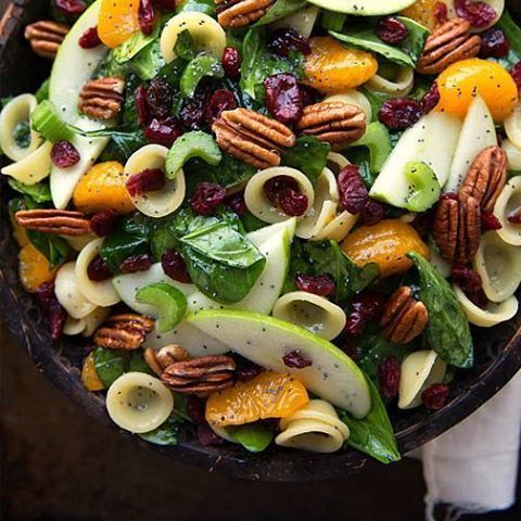 A salad with pasta , pecans , apples , spinach and cranberries