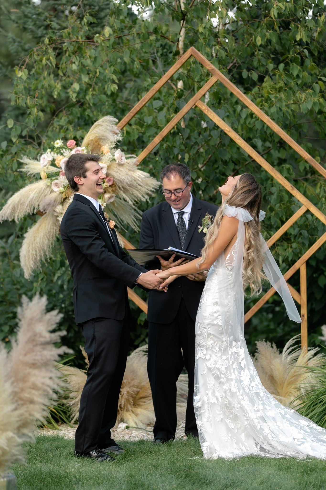A bride and groom are holding hands during their wedding ceremony.