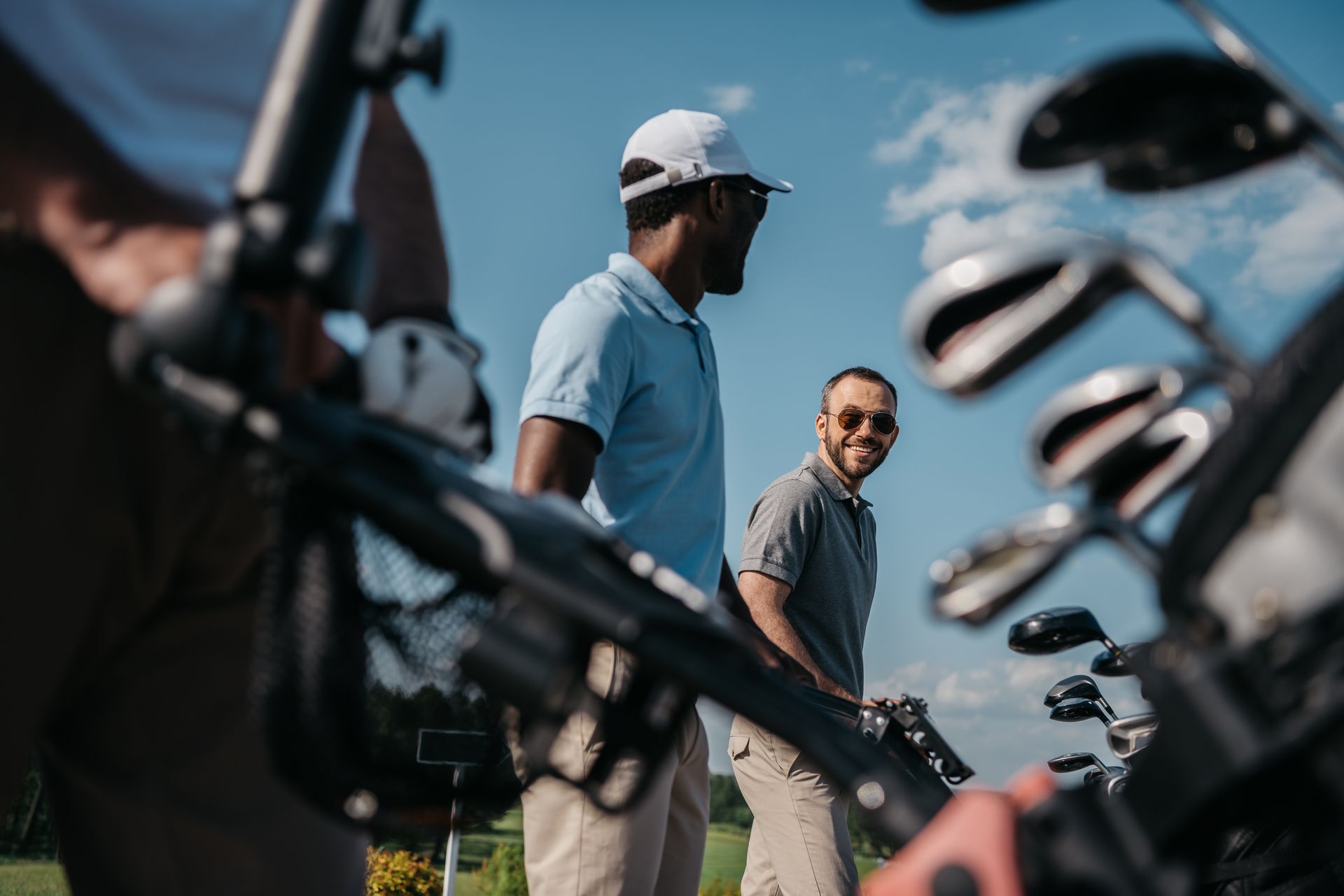 Two men are standing next to each other on a golf course.