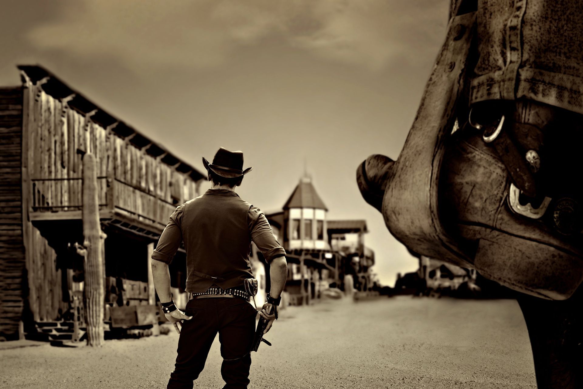 A man in a cowboy hat is standing in front of a building