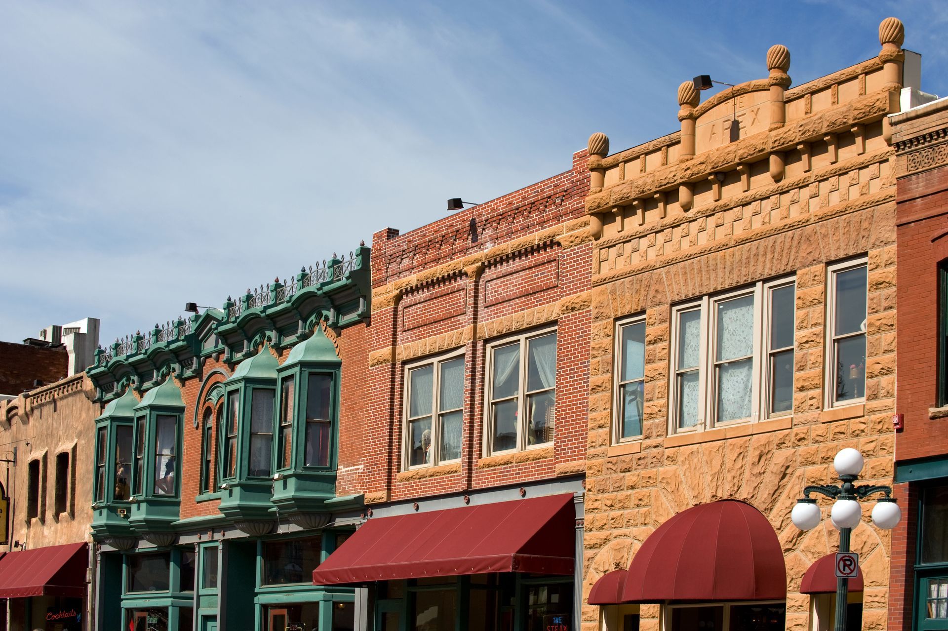 A row of brick buildings with red awnings on them