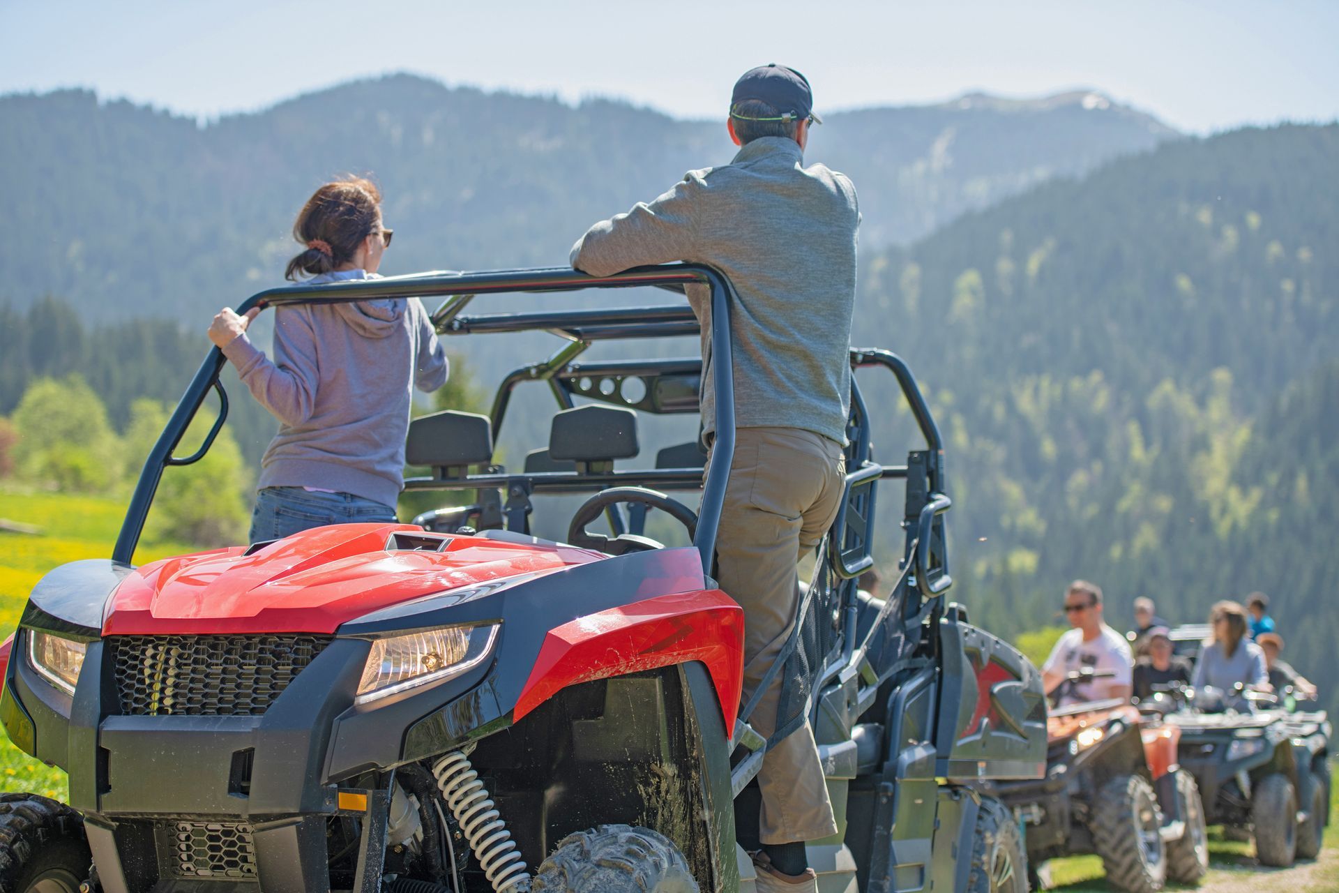 A group of people are riding atvs in the mountains.