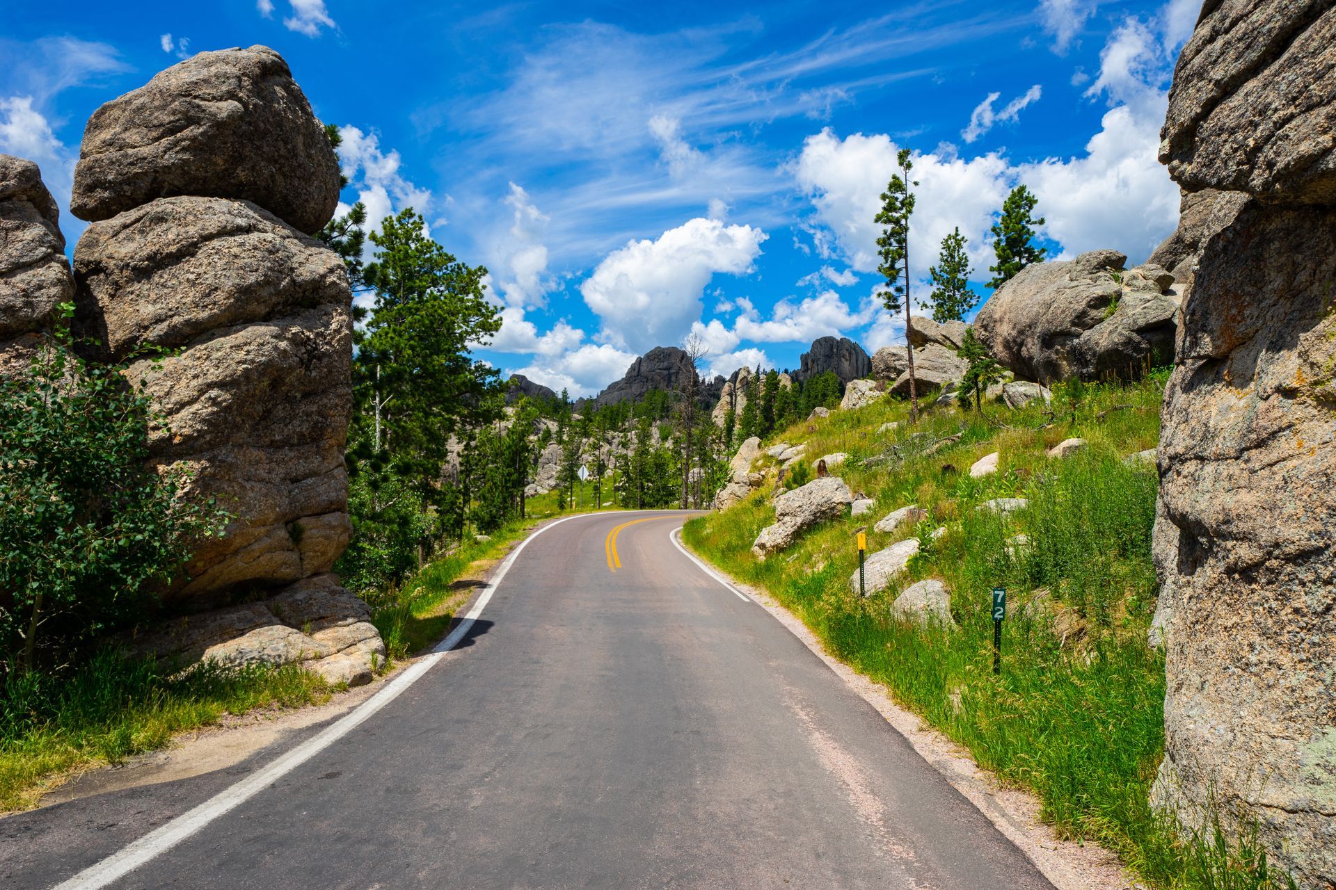 A road going through a mountainous area with rocks on both sides.