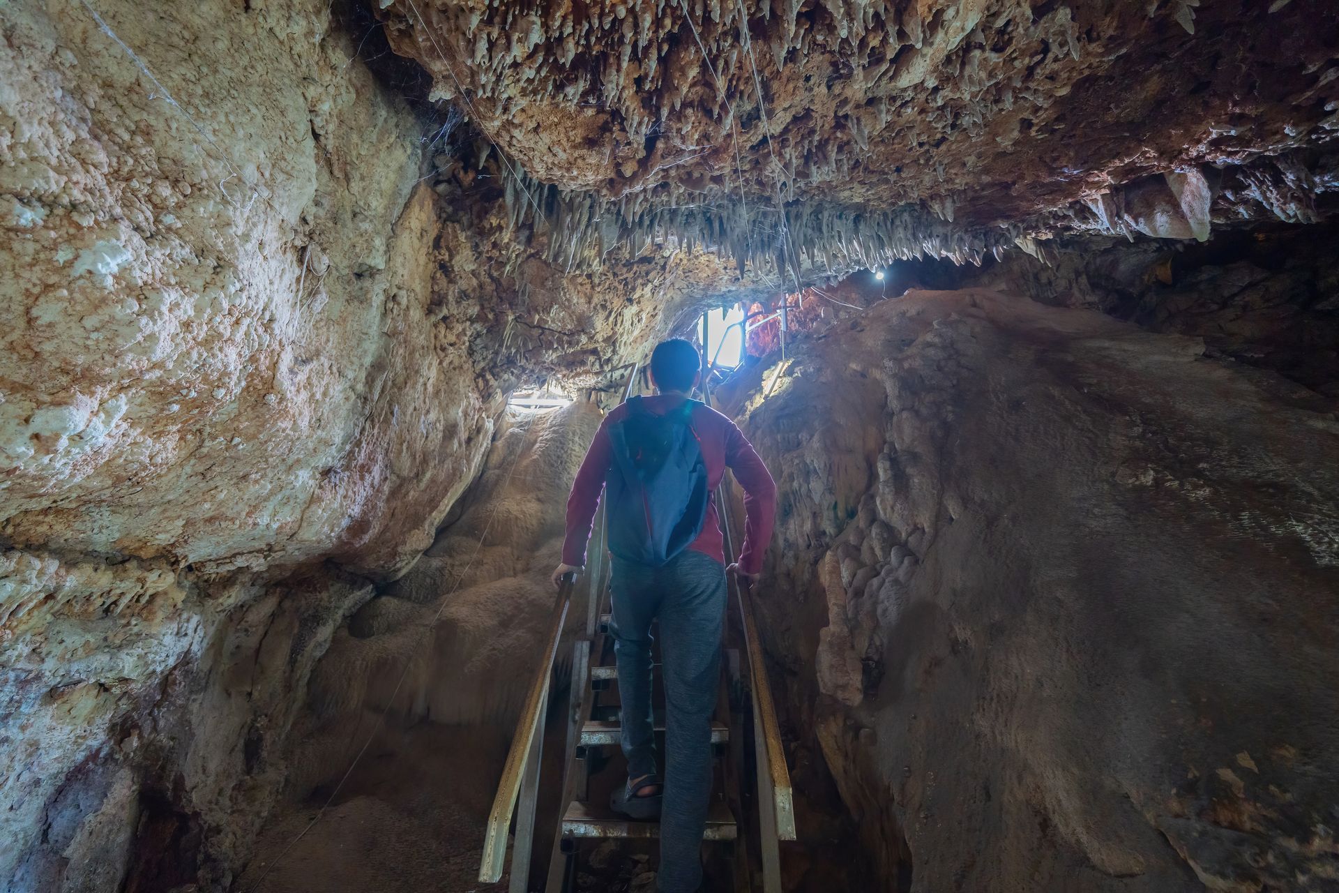 A person is walking up a staircase in a cave.