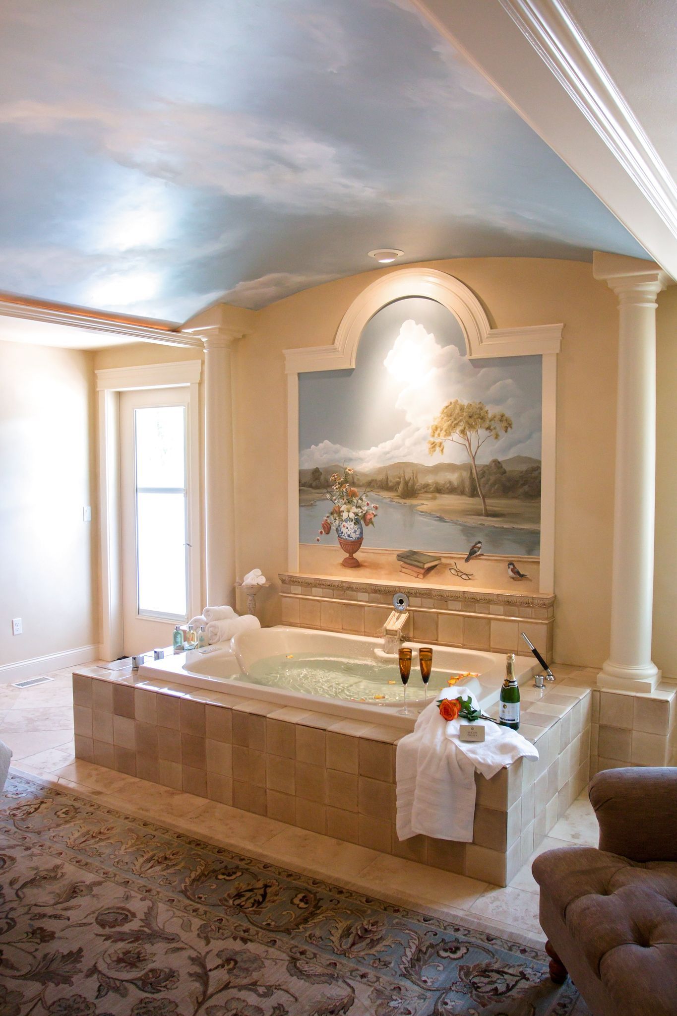 A large bathtub in a bathroom with a painting on the wall above it.