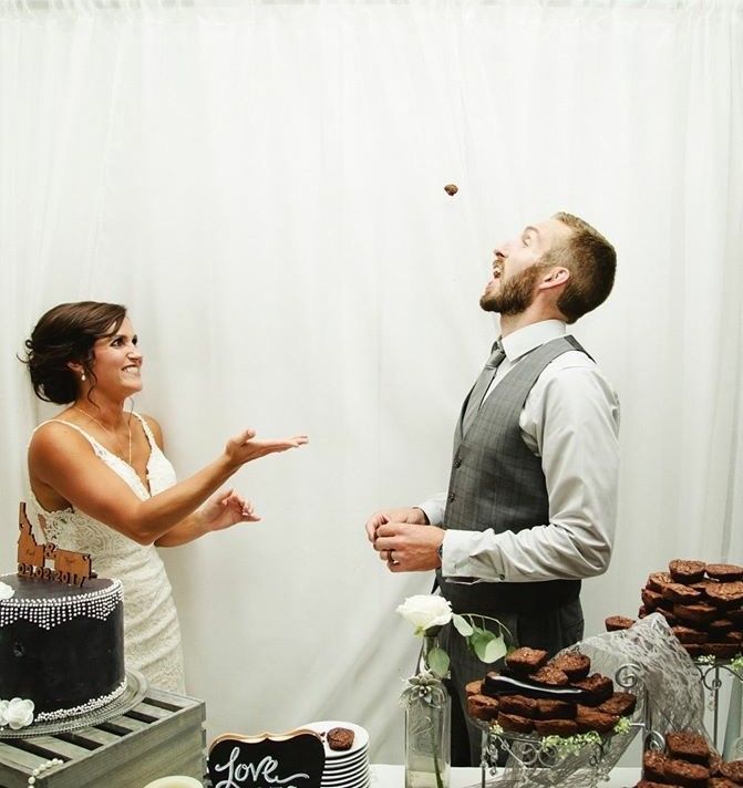 A bride and groom standing in front of a sign that says love