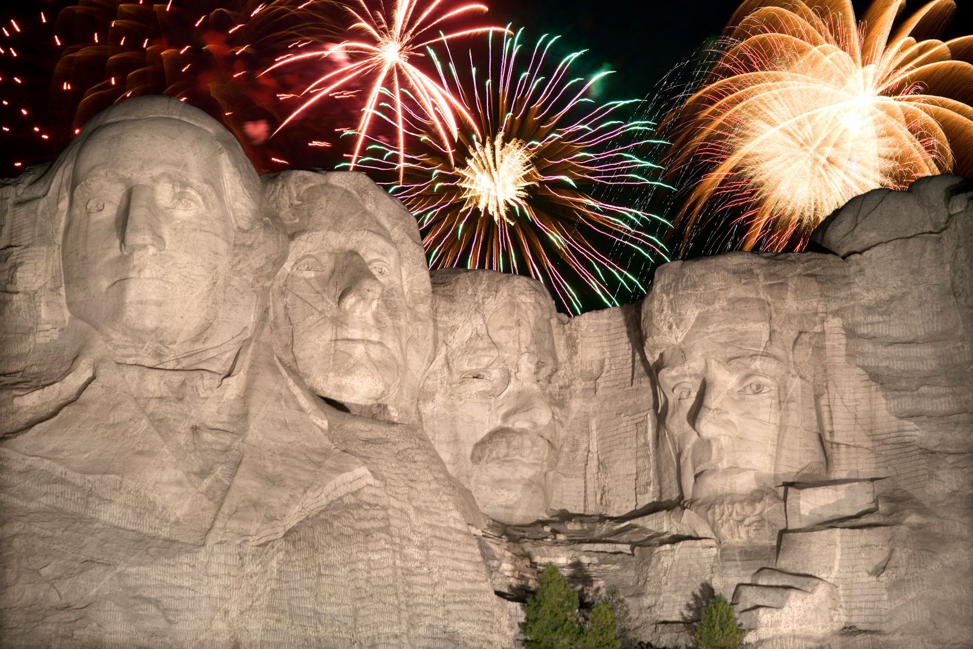 A statue of the presidents of the united states with fireworks in the background