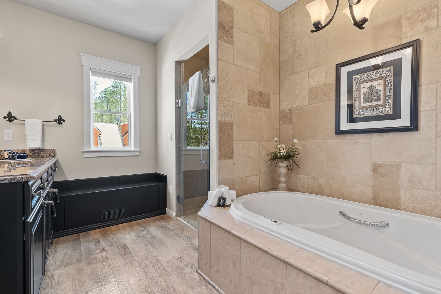 A bathroom with a tub , sink , and window.