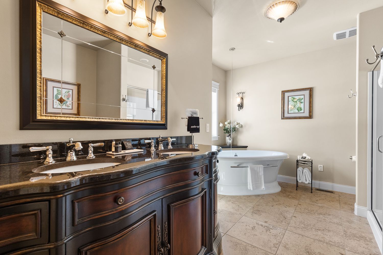 A bathroom with two sinks , a tub , and a large mirror.
