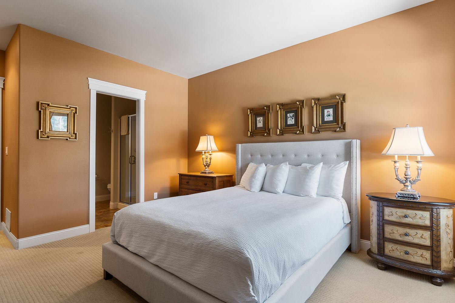 A bedroom with a king size bed and two lamps