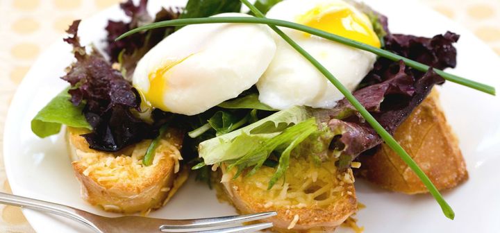 A close up of a plate of food with eggs and lettuce