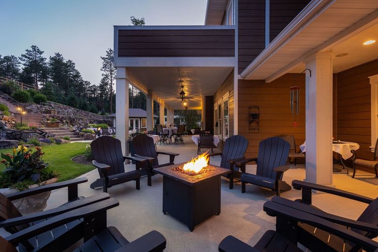 A patio with chairs and a fire pit in the middle