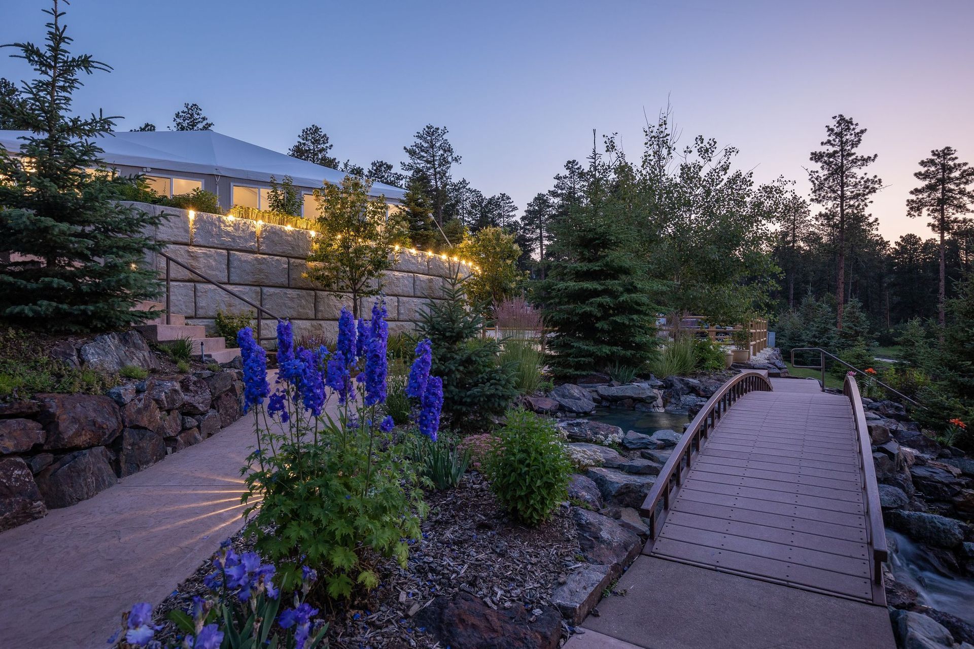 There is a bridge leading to a house in the background.