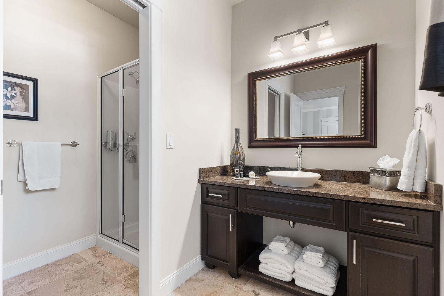 A bathroom with a sink , mirror , and walk in shower.