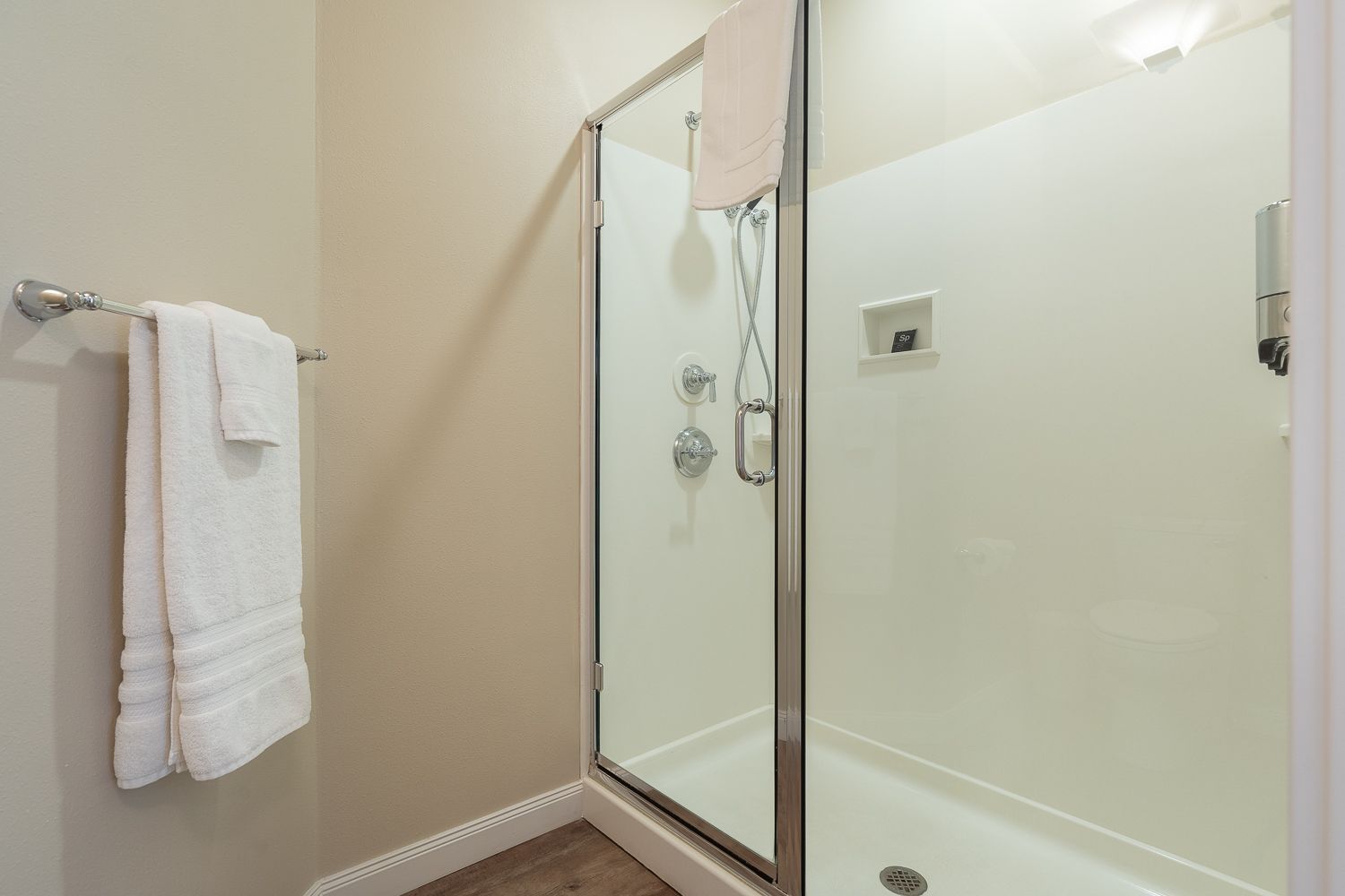 A bathroom with a walk in shower and a towel rack.