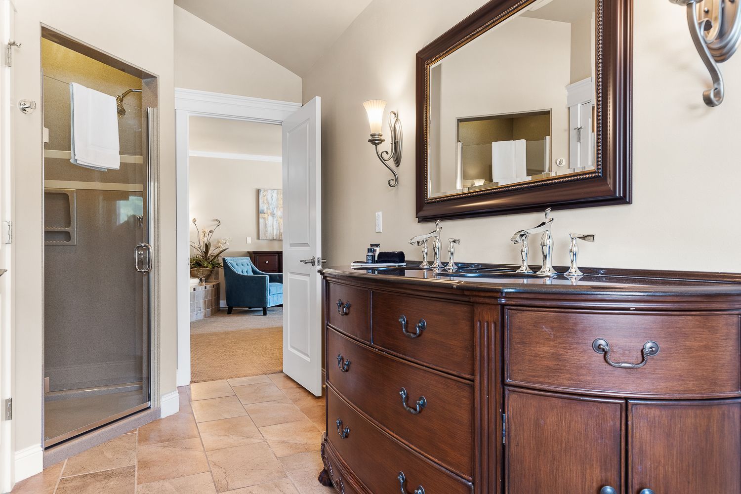 A bathroom with two sinks , a mirror and a dresser.