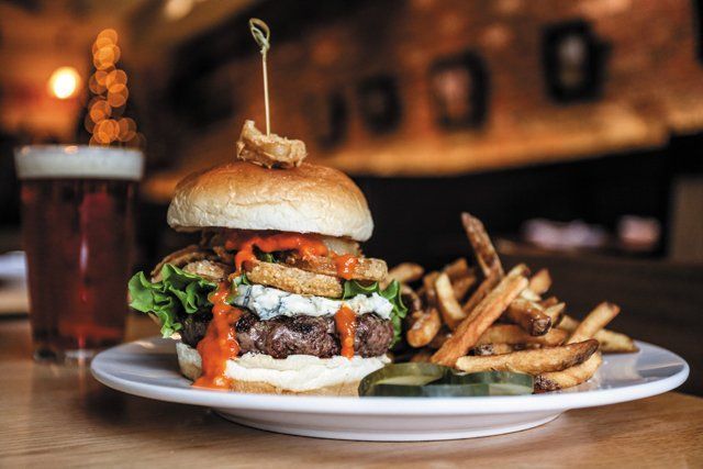 A hamburger and french fries on a white plate on a table.