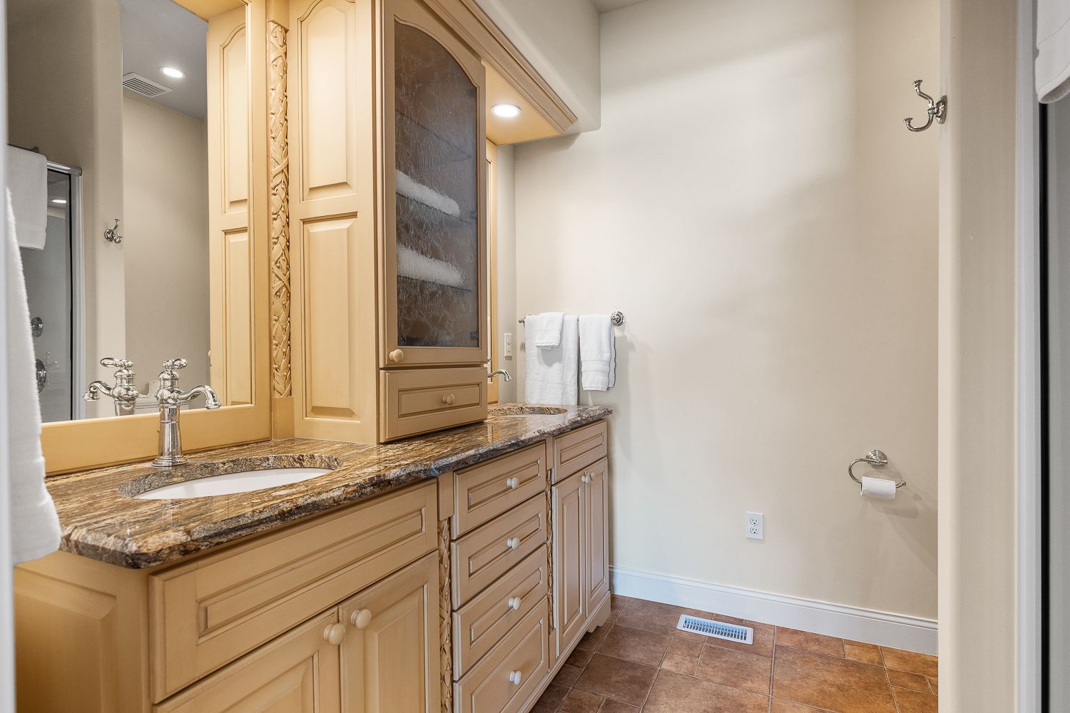 A bathroom with a sink , mirror and cabinets.