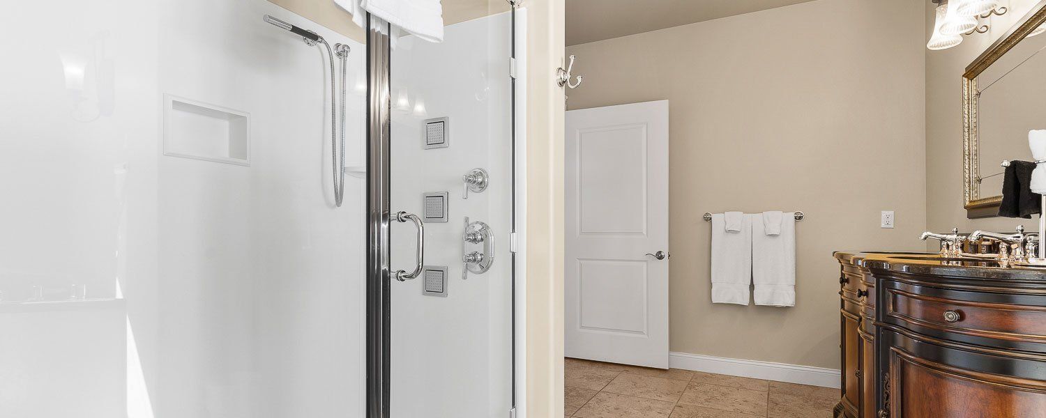 A bathroom with a walk in shower and a mirror.