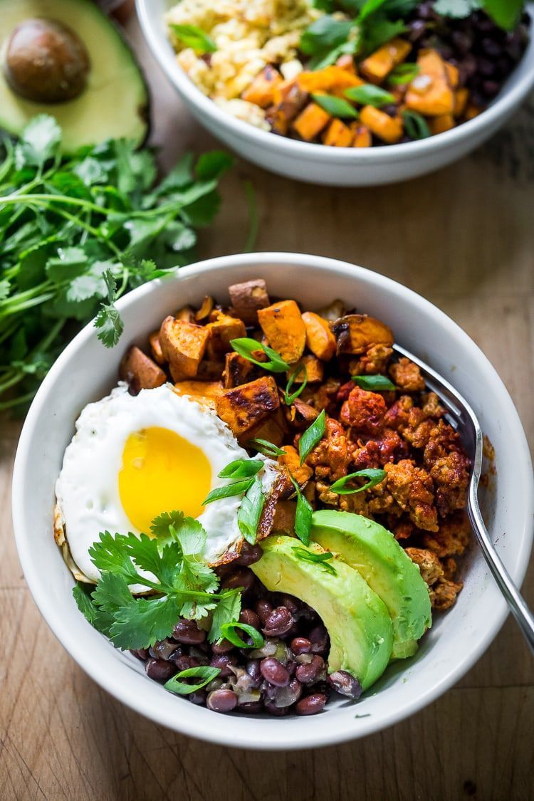 A bowl of food with a spoon in it on a table.