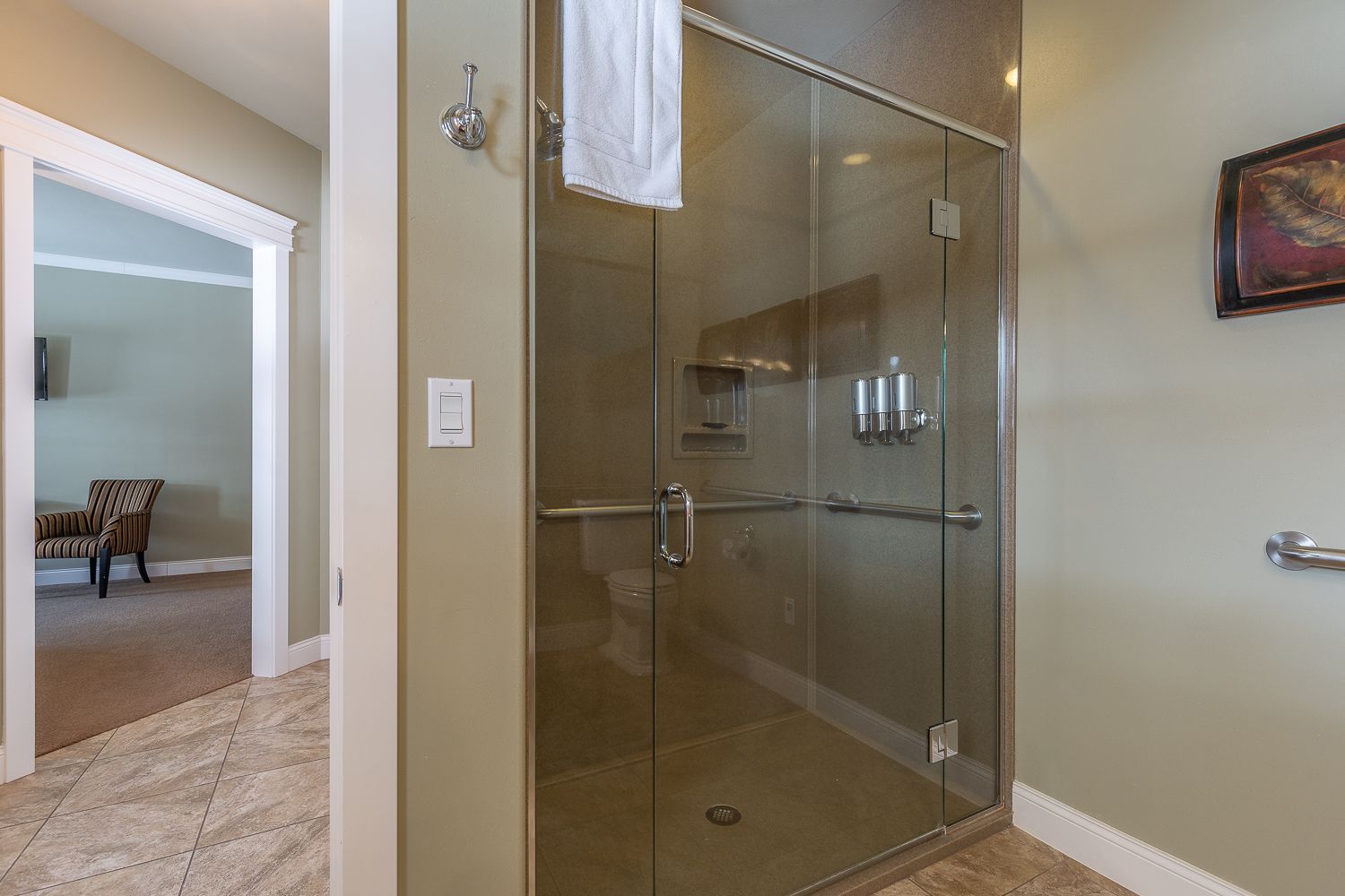 A bathroom with a walk in shower and a glass door.