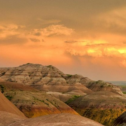 A sunset over a desert landscape with mountains in the foreground