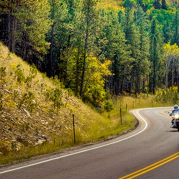 A person is riding a motorcycle down a curvy road.