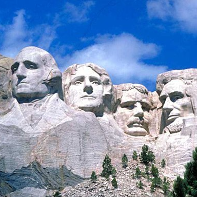 A group of statues of presidents on top of a mountain.