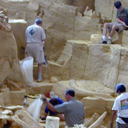 A group of people are working on a statue of a dinosaur