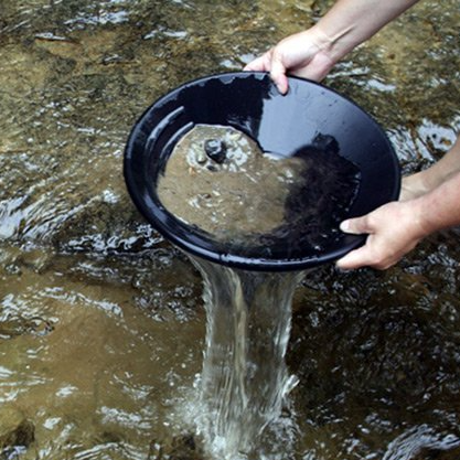A person is holding a black bowl over a stream of water