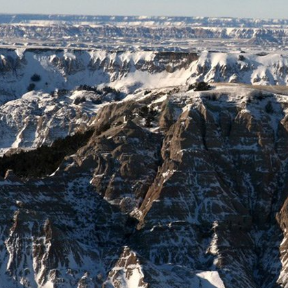 A mountain covered in snow with the ocean in the background