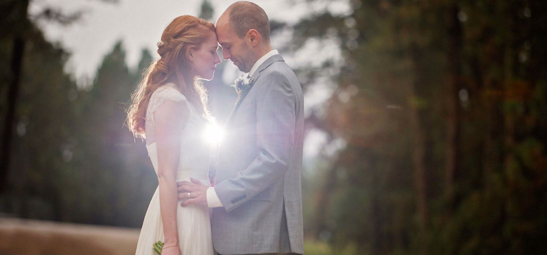 A bride and groom are standing next to each other and looking into each other 's eyes.