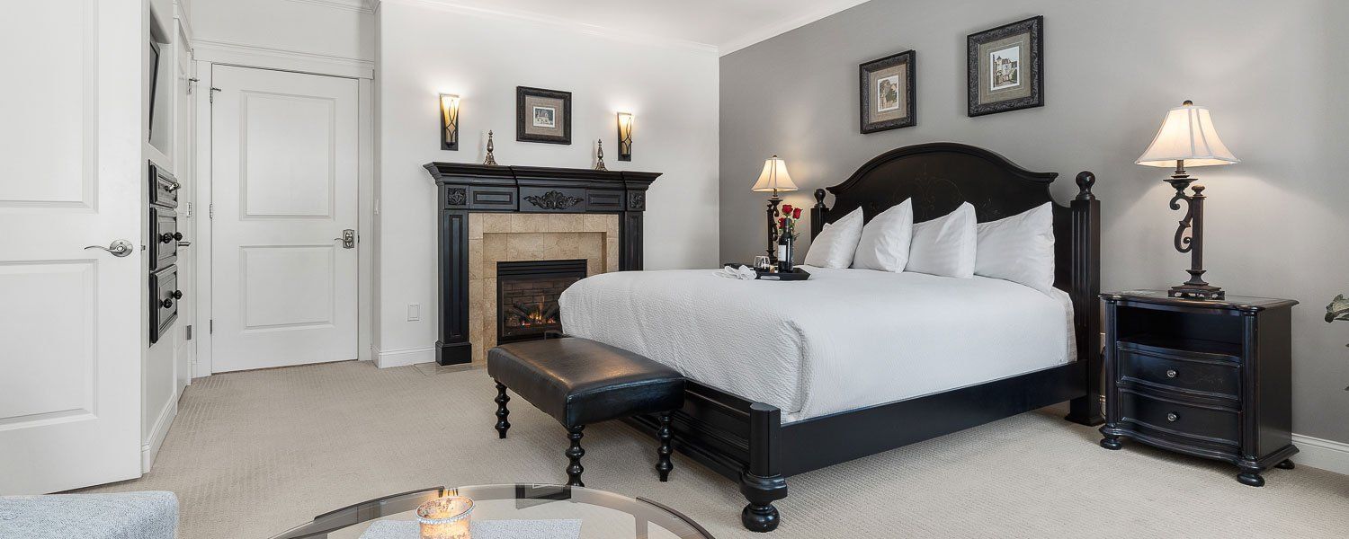 A bedroom with a king size bed and a fireplace.