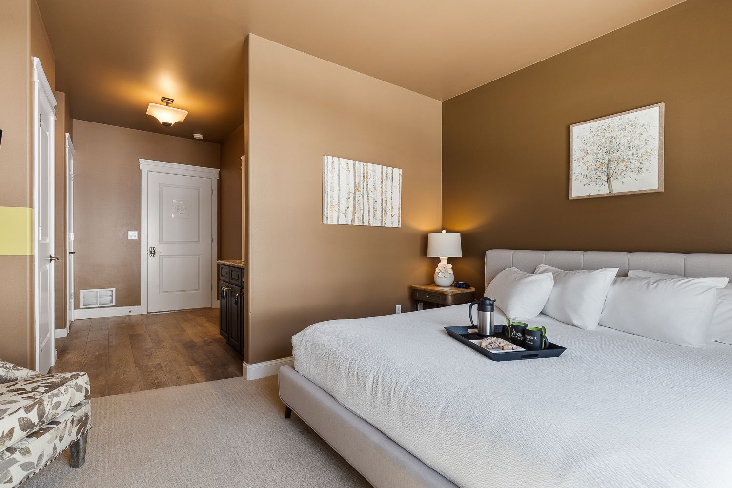 A bedroom with a large bed and a tray on the bed.
