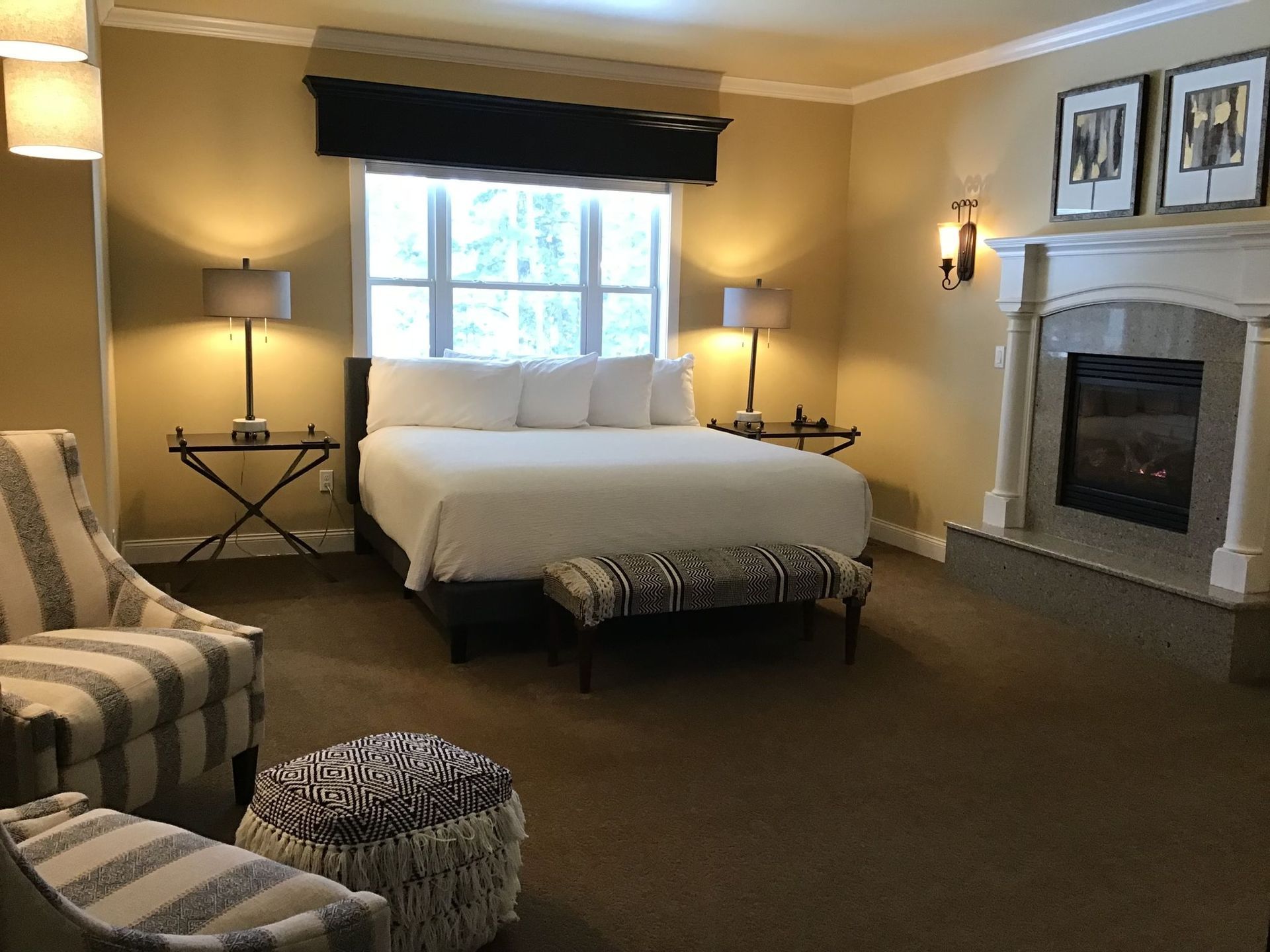A bedroom with a king size bed and a fireplace.