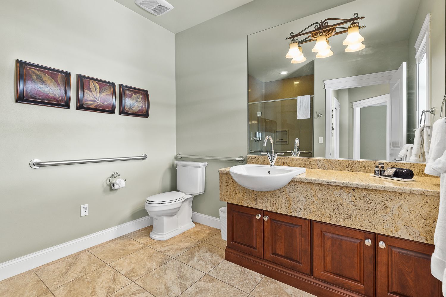 A bathroom with a toilet , sink , and mirror.