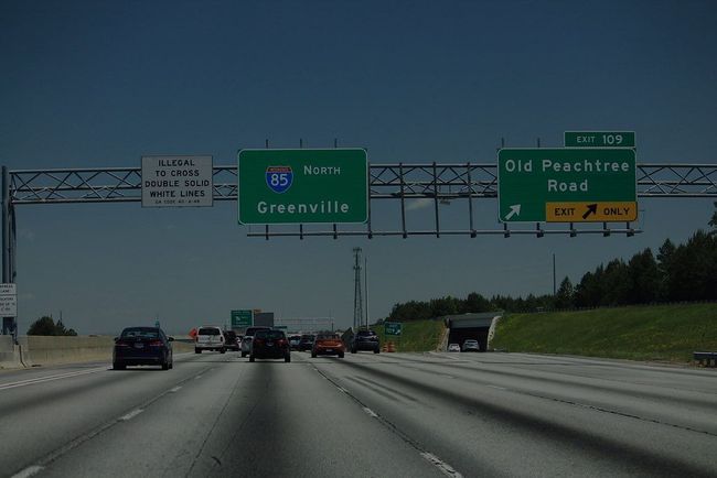 A highway with a green sign that says old peachtree road