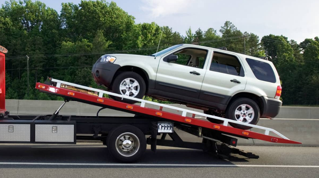 A white suv is being towed by a tow truck