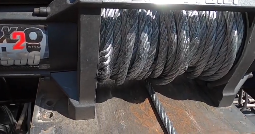A close-up of a winch with a steel cable. affordable winch out greenville sc