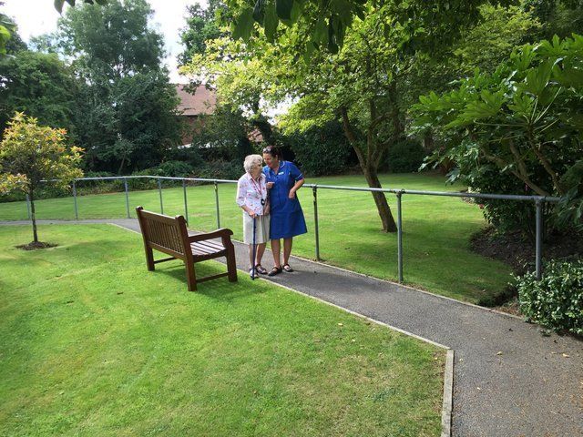 Resident and nurse walking in park at Avon Park Care Home Southampton
