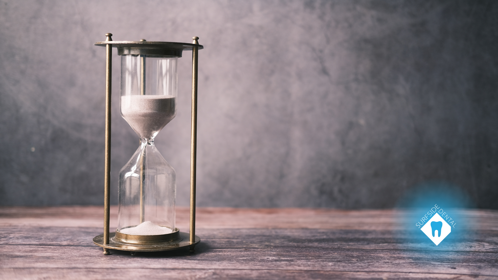 A hourglass is sitting on a wooden table.