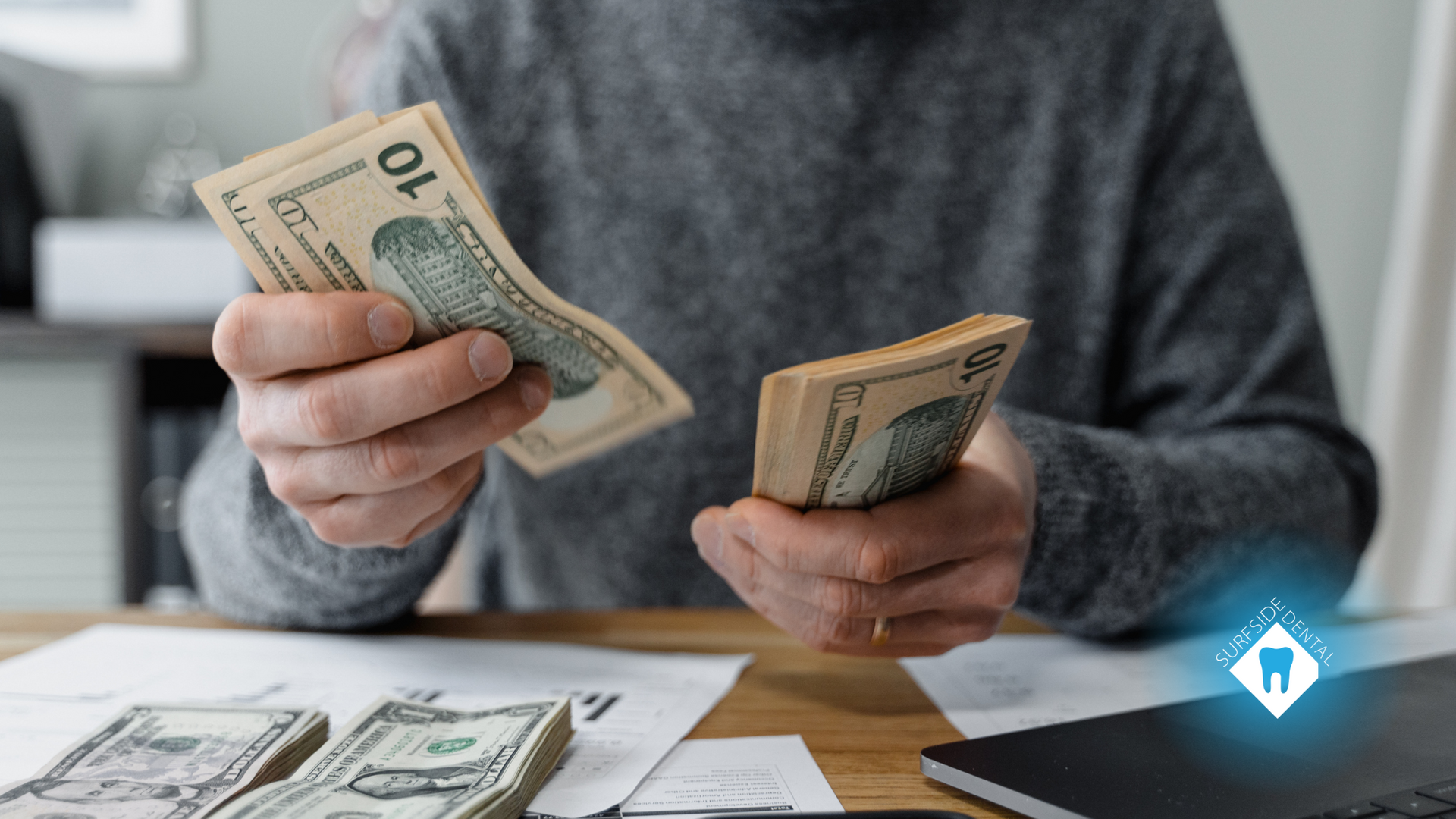 A man is sitting at a table counting money.