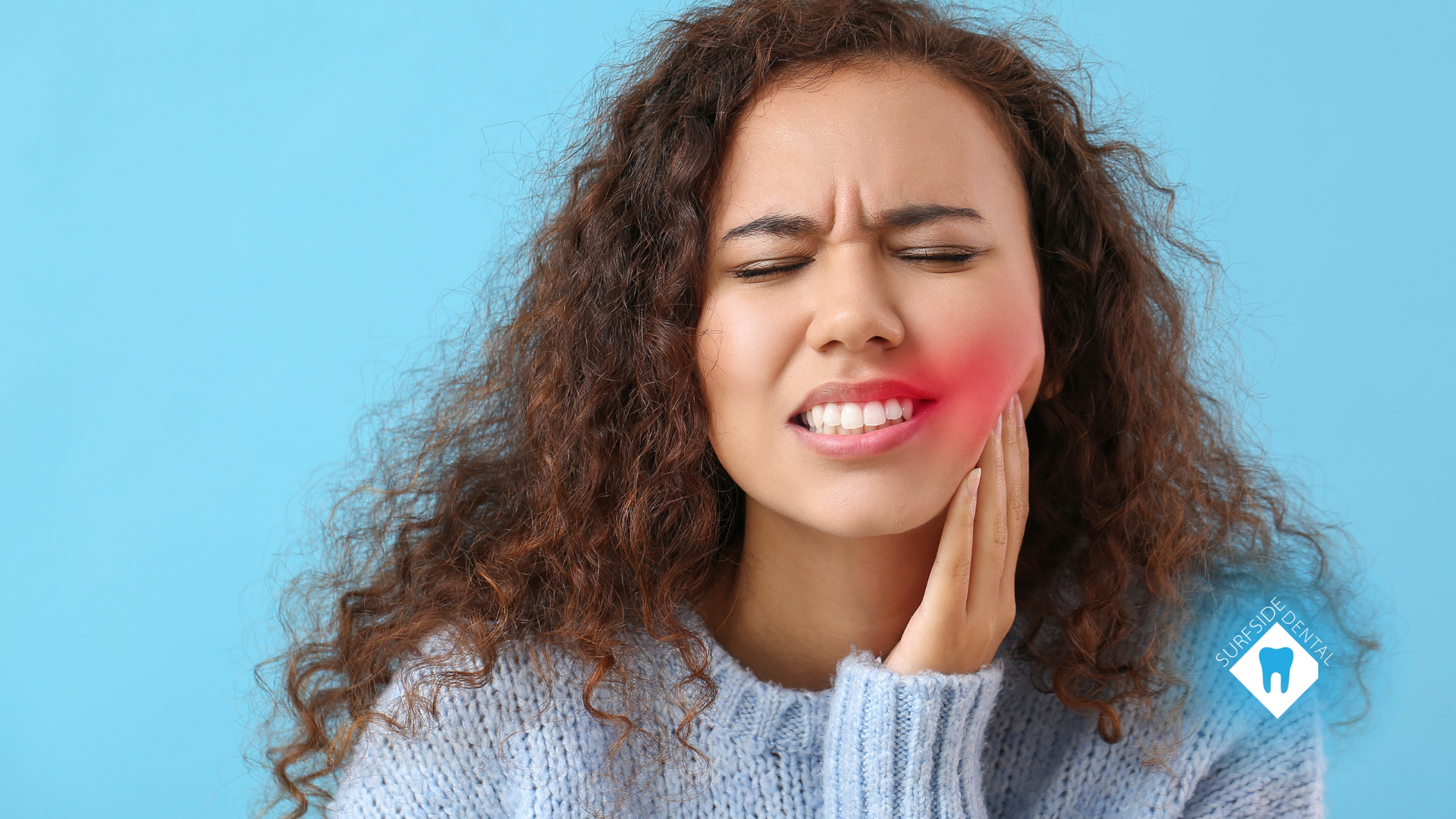 A woman is holding her face in pain because of a toothache.