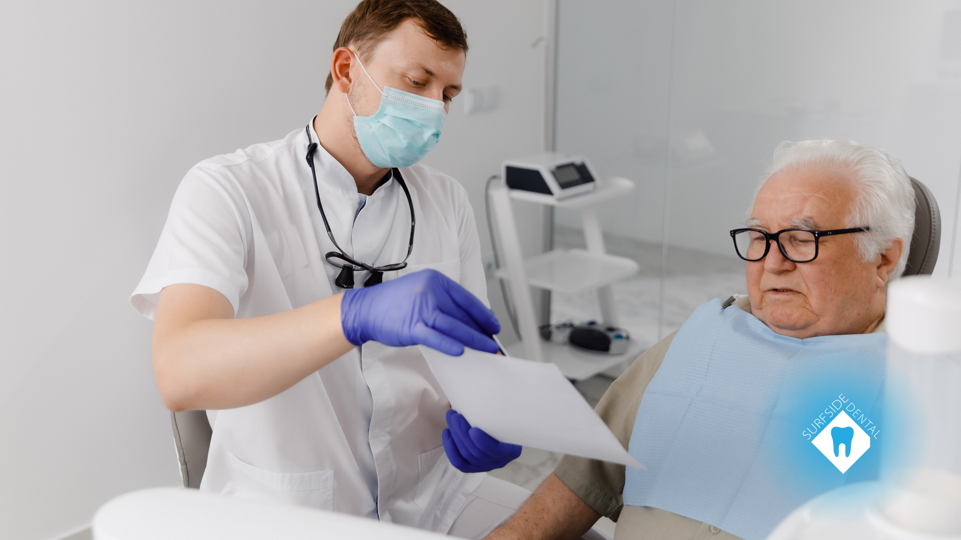 A dentist is talking to an elderly man in a dental chair.